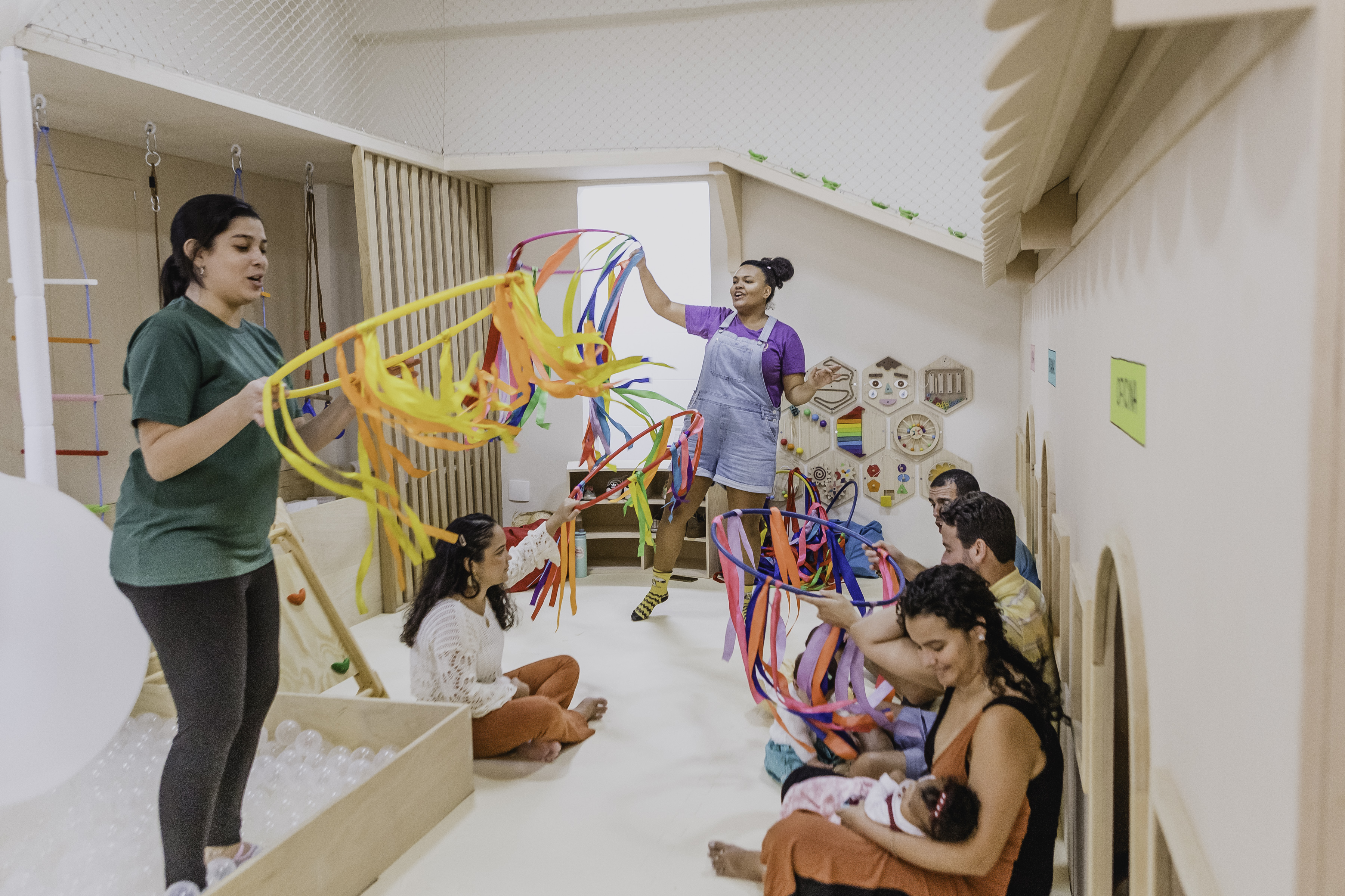 Monitoras animando festa com arcos de fitas coloridas