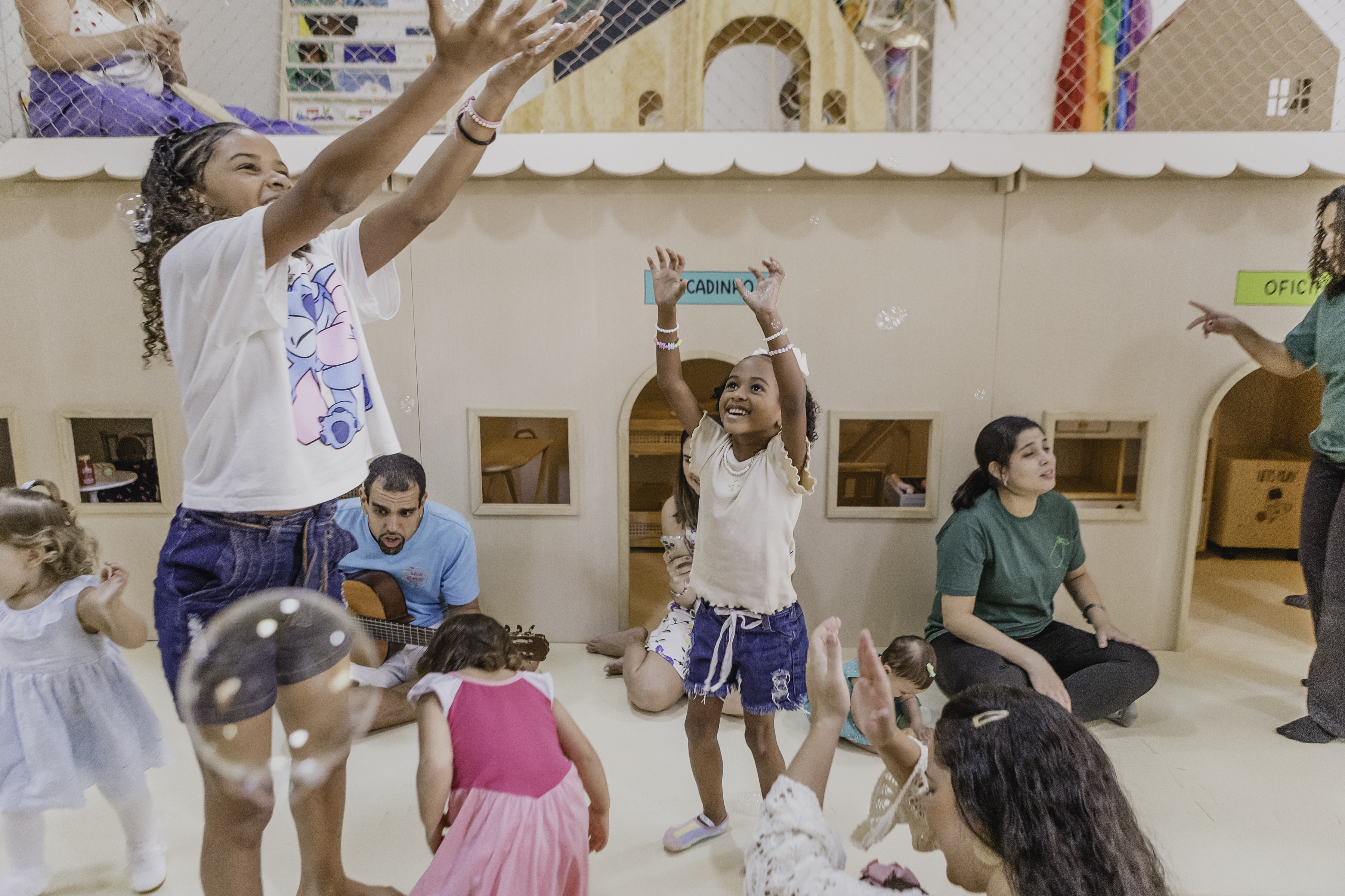 Grupo de crianças e adultos brincando com bolhas de sabão