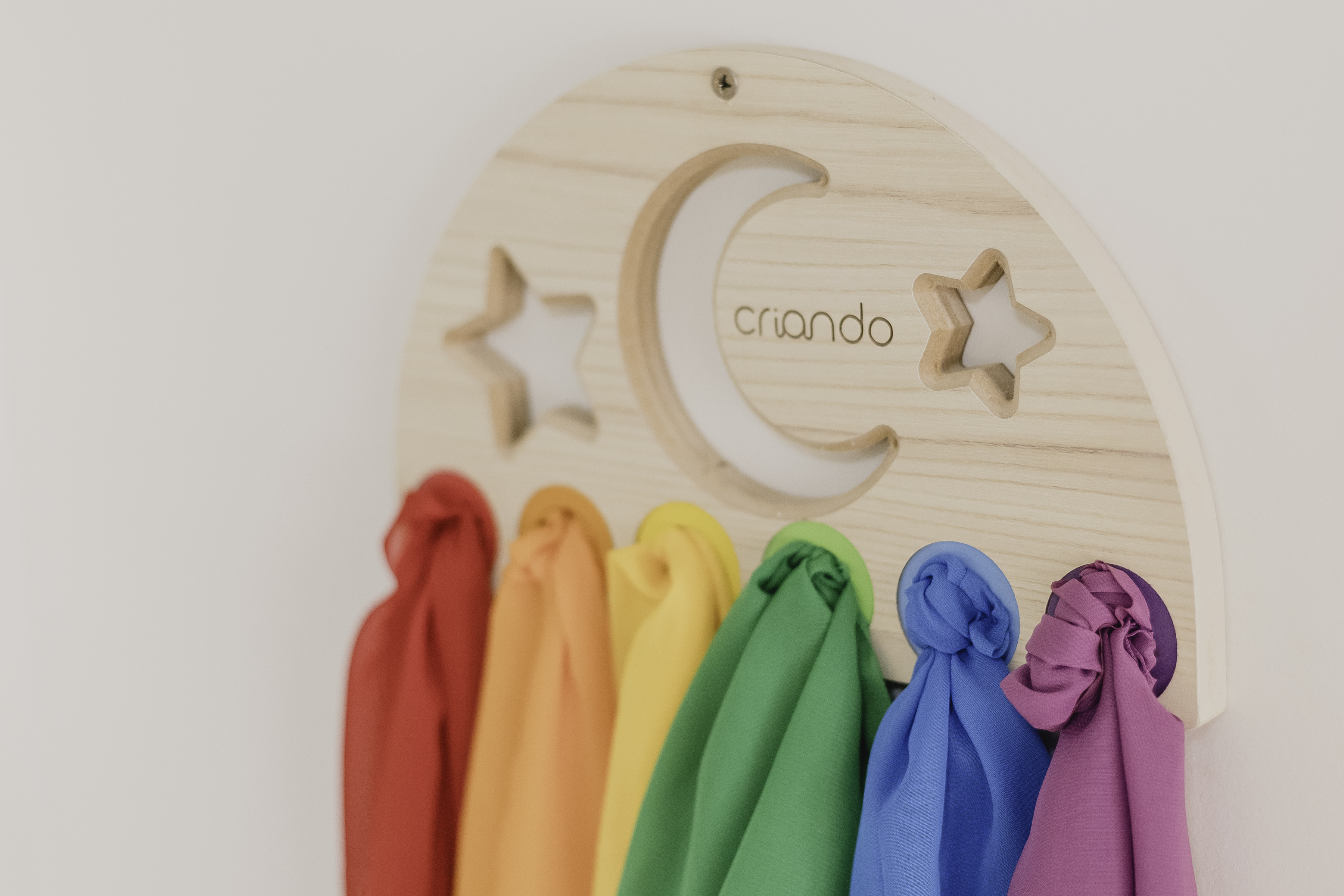 Painel decorativo de lua e estrelas com lenços coloridos pendurados