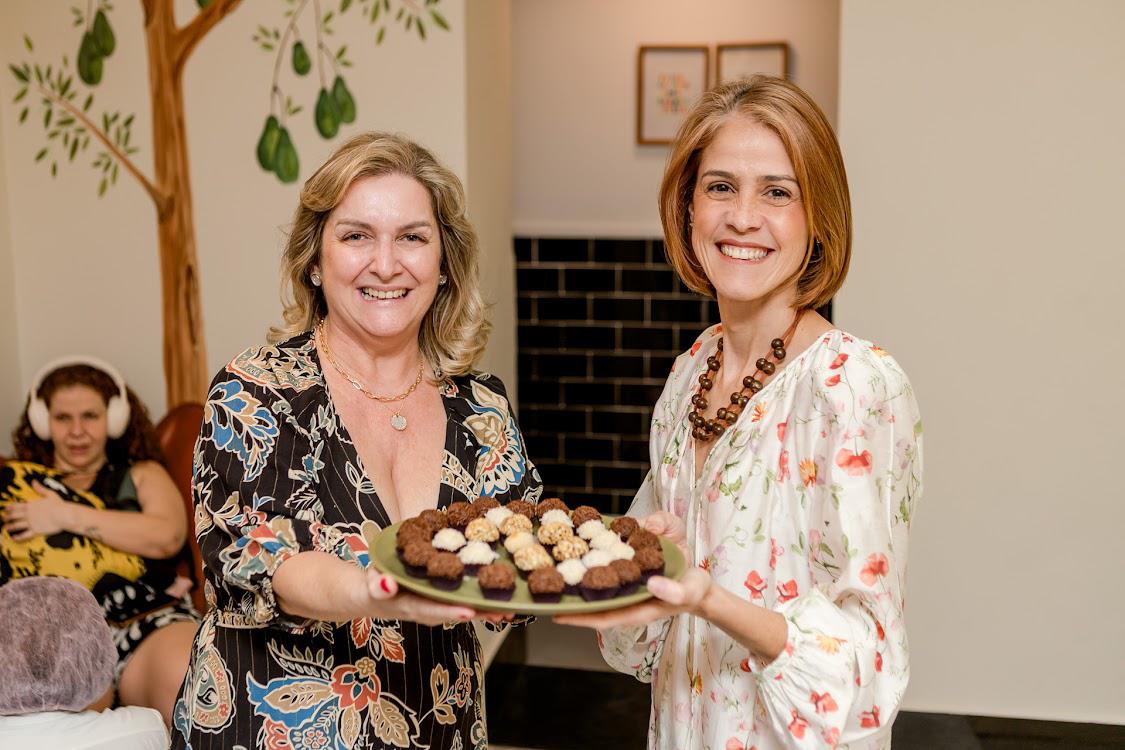 Patrícia e Luana sorrindo com bandeja de brigadeiros no Abacateiro Botafogo